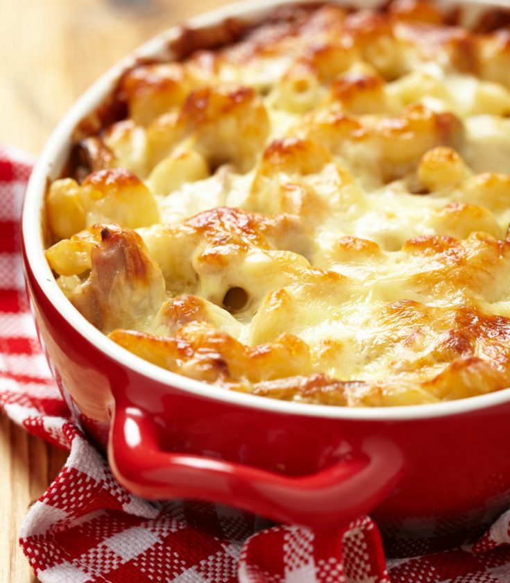 Penne Noodles, tomato sauce, chicken and melted cheese in a red enamel baking dish